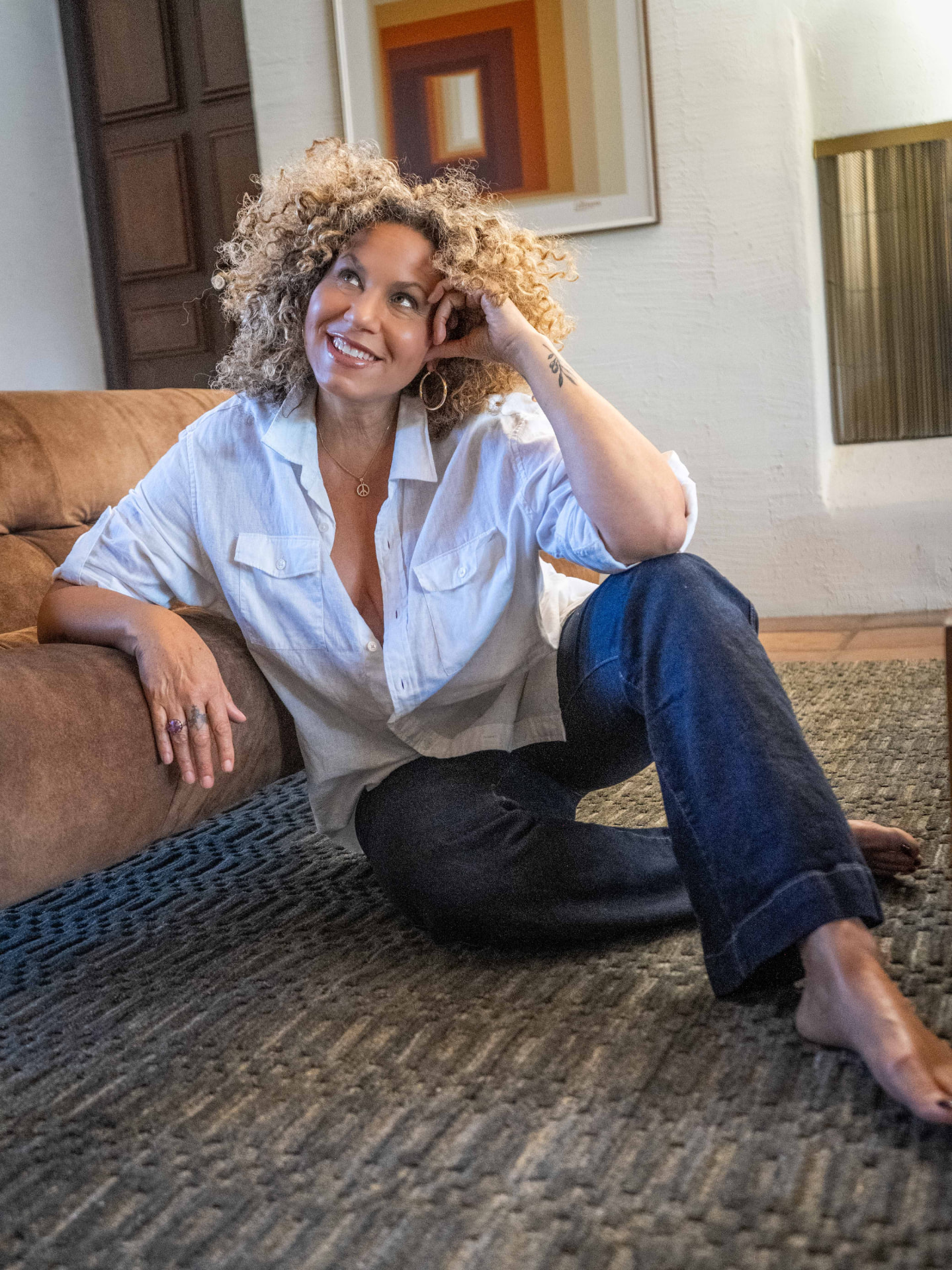 Hopi relaxing on the couch in her white shirt and jeans
